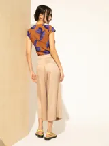 Pantalón de lyocell color beige, de corte ancho con tabla central en el delantero, bolsillos laterales y traseros.