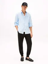 Pantalón de jogging negro de corte regular y pierna cónica, confeccionado en mezcla de algodón y poliéster. Presenta cintura con cordón, bolsillos laterales y trasero, y logo de Tommy Hilfiger bordado en la cadera.