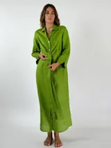 Vestido camisero largo color verde lima, con cuello camisero, mangas largas con puños abotonados, cierre frontal con botones y lazo anudado en la cintura.