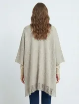 Cardigan tipo kimono de tejido suave, color negro y blanco con patrón de espiga (herringbone). Presenta bolsillos delanteros y terminación con flecos en el ruedo.