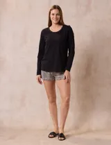 Pijama de dos piezas compuesto por una remera negra de manga larga con escote redondo y bolsillo en el pecho, y un short con estampado animal print.