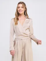 Blusa negra de satén, marca Allie Rose, con cuello con solapa y escote en V. Diseño cruzado con lazo de ajuste lateral y manga larga con pretina, ojal y botón.