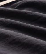 Bermuda deportiva gris oscuro confeccionada en poliamida, de corte corto, con cintura elástica, cordón ajustable y ribetes laterales en color blanco.