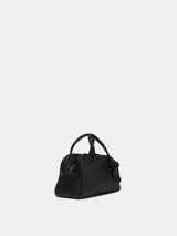 Cartera tipo bowling de cuero granulado negro, con asas superiores, correa ajustable y extraíble, y detalle de lazo en el lateral.