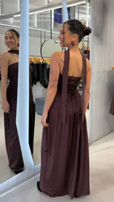 Vestido largo color marrón chocolate, con diseño halter, espalda descubierta con tiras cruzadas estilo corsé y falda larga con vuelo.