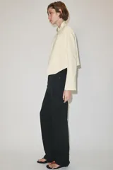 Jeans de tiro medio color negro, de corte recto y largo completo, con diseño clásico de cinco bolsillos, trabillas para cinto y cierre frontal con cremallera y botón.