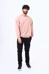 Buzo de felpa color rosado con cuello redondo, mangas largas y logo bordado en el pecho.