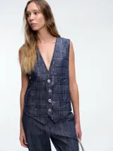 Chaleco sastrero de denim negro con diseño de cuadros y aplicación de lentejuelas sutiles. Presenta escote en V, cierre frontal con botones metálicos y bolsillos delanteros.