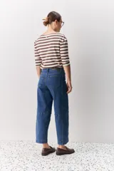 Jean de corte barrel, tiro alto, con silueta amplia que se estrecha hacia el tobillo. Confeccionado en denim azul oscuro con costuras a contratono.