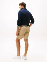 Bermuda de sarga de algodón elástico con corte slim, incluye cinturón, cierre de cremallera, bolsillos delanteros y traseros con botón.