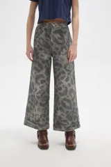 Pantalon de jean de corte ancho y tiro alto, con diseño estampado animal print en tonos grisáceos. Presenta pinzas en la cintura y ruedo con doblez.