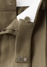 Pantalón de lino verde militar, de diseño recto y tiro alto, con detalle de pinzas y trabillas en la cintura.