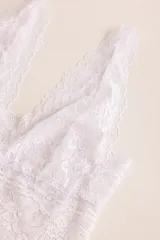 Topcito tipo bralette de encaje negro con escote en V profundo y tirantes anchos. El encaje es elastizado para un ajuste cómodo.