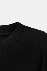 Top de algodón con cuello redondo, diseño sin mangas con hombreras marcadas y detalle de pliegues. Presenta un bajo acabado tipo globo con elástico.