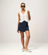 Short pollera de estilo sastre en color azul marino, confeccionado en mezcla de poliéster y viscosa, con diseño cruzado tipo envolvente.