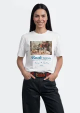Remera blanca de manga corta con cuello redondo y estampado frontal tipo cuadro con texto decorativo en azul.
