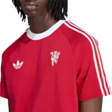 Remera de fútbol Adidas Originals del Manchester United, color rojo con cuello redondo y detalles en blanco, incluyendo las clásicas tres tiras en las mangas, el logo del trébol y el escudo del club en el pecho.