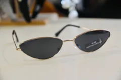 Lentes de sol con marco dorado y lentes triangulares negros. Cuentan con protección UV 400 y están habilitados por el Ministerio de Salud Pública.