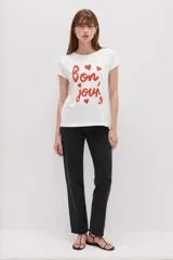 Remera blanca de algodón de manga corta, con cuello redondo y estampa frontal en color rojo con la leyenda "bon, jour" acompañada de pequeños corazones.