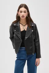 Campera estilo biker de cuero sintético color negro, con cierre frontal cruzado, solapas con botones a presión y bolsillos laterales con cierre.