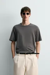 Camiseta de corte relaxed fit, confeccionada en mezcla de algodón y lino, con cuello redondo y mangas cortas.