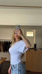 Remera manga corta básica color blanco, confeccionada en algodón, con ajuste en la cintura y frunce regulable en el lado derecho.