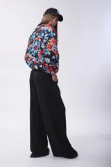 Campera bomber acolchada con cierre frontal, diseño estampado floral multicolor sobre base negra, cuello, puños y ruedo elásticos.