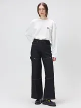 Pantalón de tiro medio y pierna ancha confeccionado en denim de algodón grueso. Presenta un diseño a rayas verticales en tonos azul y celeste, con costuras en contraste color rojo, bolsillos laterales tipo cargo y remaches metálicos.