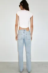 Jeans de tiro bajo con diseño de cinco bolsillos y pernera recta. Cierre frontal con cremallera y botón metálico.