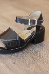 Sandalias de cuero color marrón, con faja frontal ancha con detalle de textura en relieve, plataforma sutil, taco ancho y pulsera ajustable con hebilla en el tobillo.
