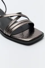 Sandalias de vestir color peltre con tiras finas, taco medio cuadrado y pulsera al tobillo con hebilla.