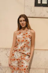 Top sin mangas de lino y algodón color beige con estampado de lobos alados, labios rojos y texto.