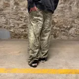 Pantalón de corte super baggy con estampado de piel de serpiente en tonos grises y beige.