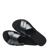 Sandalias tipo chinela Havaianas con diseño de tiras cruzadas en el empeine y acabado metalizado. Presentan una base texturizada con el logo de la marca grabado en las tiras y en la plantilla.
