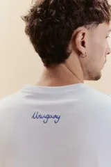 Remera de manga corta color blanco con estampa minimalista en azul que incluye iconos de un mate, un sol y olas.