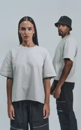 Remera de corte boxy, silueta amplia y recta, confeccionada en algodón premium. Presenta cuello redondo y mangas cortas, con un diseño de calce relajado.