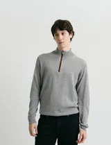 Sweater de punto azul con medio cierre frontal, cuello alto y detalles en símil nappa en la cartera del cierre y coderas.