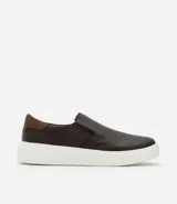Championes tipo slip-on de cuero marrón oscuro, con detalle de refuerzo en el talón en tono marrón más claro y suela de goma blanca en contraste.