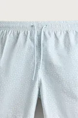 Short de baño celeste con estampado geométrico paisley, cintura elástica con cordón ajustable, bolsillos laterales y bolsillo trasero.