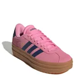 Championes Adidas modelo VL Court Bold, de diseño inspirado en el skate con plataforma. Presentan una capellada de gamuza en color rosado con las icónicas tres rayas laterales en azul marino y suela de goma color caramelo.