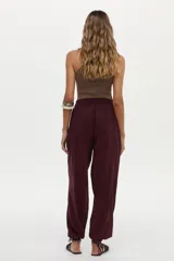 Pantalón babucha bordó con elástico en la cintura trasera y bolsillos laterales, de corte amplio y fluido.