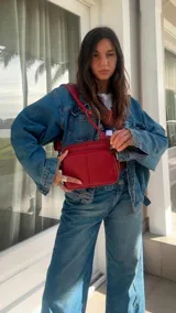 Bandolera de símil cuero color rojo, con doble bolsillo principal, un bolsillo frontal y un bolsillo trasero. Incluye correa ajustable.