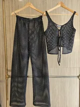 Pantalón de tejido calado color negro, de corte recto y cintura elástica.