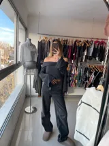 Top de punto gris oscuro con escote off-shoulder y mangas largas acampanadas.