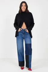 Pantalón de jean de corte recto y tiro alto, con diseño patchwork que combina diferentes tonos de denim azul y negro. Presenta bolsillos delanteros funcionales y cierre frontal con botón.