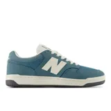 Championes New Balance modelo 480, color azul petróleo con detalles en blanco. Presentan una silueta de corte bajo, capellada de gamuza y malla, y logo 'N' lateral en blanco. La suela es de goma blanca con borde negro.