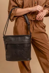 Bandolera mediana de cuero sintético color negro, con correa regulable, bolsillo frontal con cierre y compartimento principal.