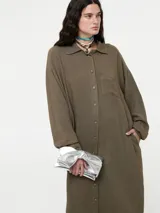 Vestido camisero negro de lino con botones delanteros y bolsillos ocultos.