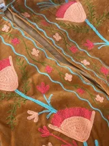 Chaqueta de terciopelo color camel-oliva de corte relajado, con cuello mao y bordado denso de tulipanes grandes en tonos rosa y durazno con ramas celestes en todo el diseño.