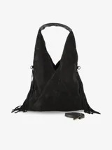 Cartera de gamuza negra con diseño amplio y silueta relajada, decorada con flecos laterales. Incluye un asa superior integrada, correa desmontable y un pequeño monedero frontal con cierre.